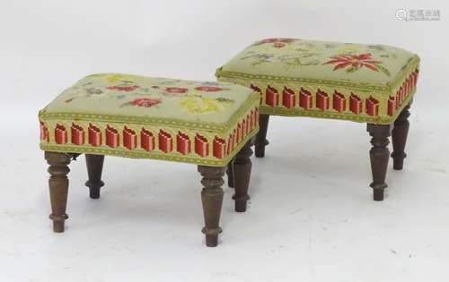 A pair of early 20thC mahogany footstools with upholstered tops and raised on turned tapering