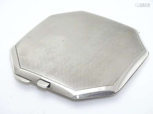 A silver compact of octagonal having engine-turned decoration. Hallmarked Birmingham 1941 maker