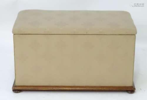 A Victorian upholstered ottoman with an overstuffed seat / lid opening to show storage space within,