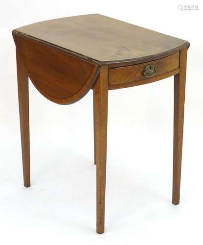 An early 19thC mahogany pembroke table with drop flaps opening to show the oval form of the table