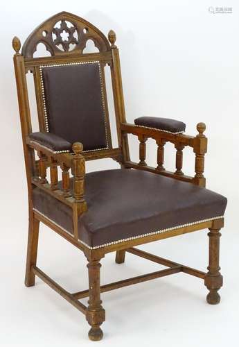 A mid 19thC Gothic armchair with a pierced lancet shaped cresting rail, Gothic tracing above an