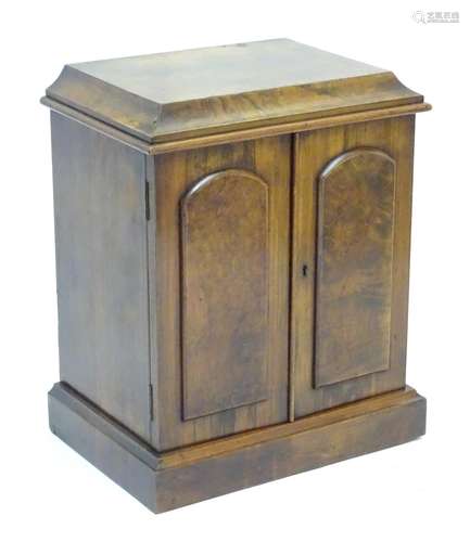 A 19thC walnut collectors cabinet with a thumb moulded top above two panelled doors and containing