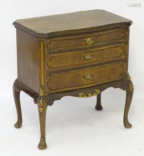 A mid 20thC walnut chest of drawers with a serpentine shaped top above three long graduated