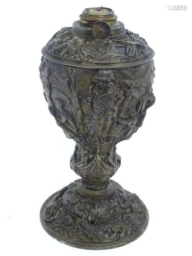 A 19thC cast oil lamp base decorated in relief, the top with stacked arms, helmets, shields, bow and