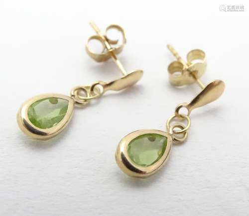 A pair of 9ct gold drop earrings set with peridot drops. Approx 3/4