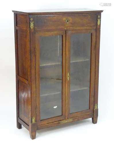 A late 19thC cabinet / bookcase in the Empire style, having a rectangular moulded top above single