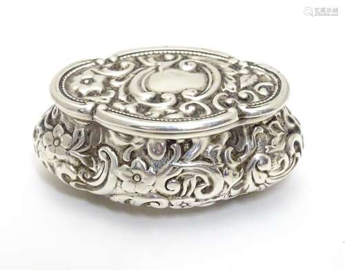 A Victorian small silver box of shaped form with embossed decoration, hinged lid and gilded