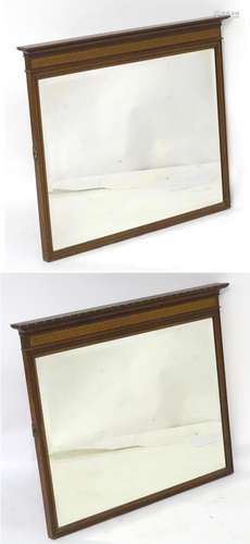 A pair of early 20thC mahogany mirrors with moulded cornices above Greek key decoration and having