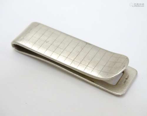 A silver money clip with engraved checked decoration. Approx 2