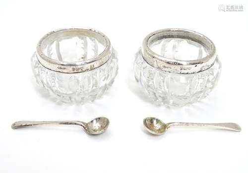 A pair of cut glass salts with silver rims hallmarked London 1902 maker Gibson & Co Ltd together