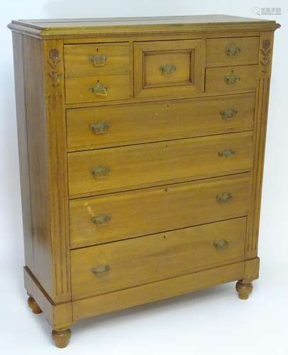 An early 20thC large walnut chest of drawers with a moulded top above a deep central drawer