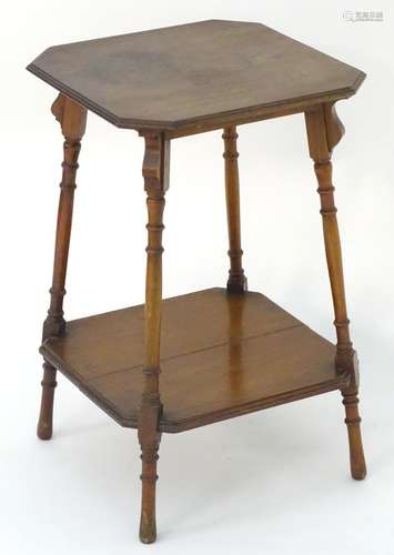 An early 20thC walnut occasional table with an octagonal top above four turned splayed legs with