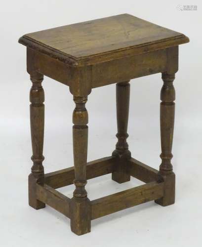 A late 19thC / early 20thC oak joint stool with a moulded surround and standing on four turned