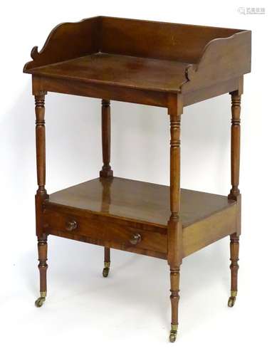 A mid 19thC mahogany washstand with a shaped upstand above four turned legs united by an under