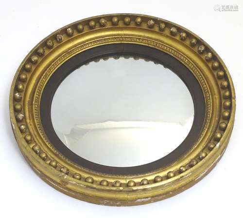 A 19thC convex mirror with an ebonised surround and a moulded frame having applied bauble decoration