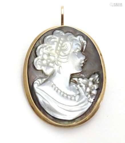 A 9ct gold pendant / brooch set with mother of pearl abalone carved cameo 1 1/2