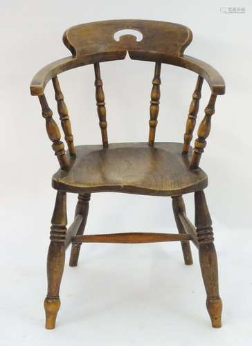 A 19thC smokers bow chair with a pierced top rail, curved backrest with turned supports above an elm