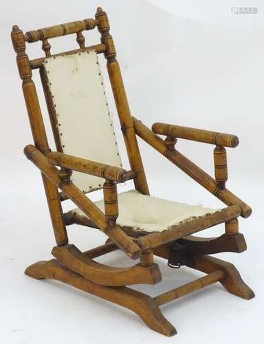 A late 19thC / early 20thC walnut childs rocking chair with a ring turned frame and sleigh style