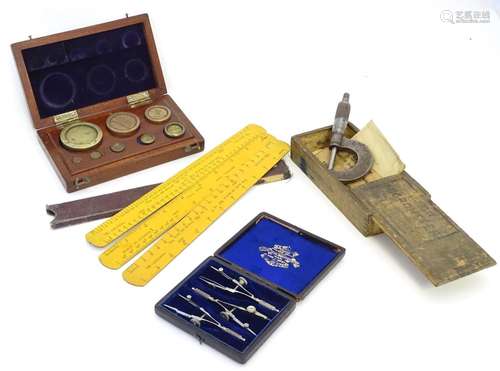 An assortment of instruments, comprising a micrometer, a boxed set of scale weights, conversion