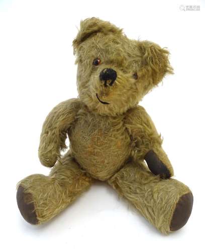 Toy: A mohair teddy bear with articulated limbs and head, pad paws, and a proud, stitched nose.