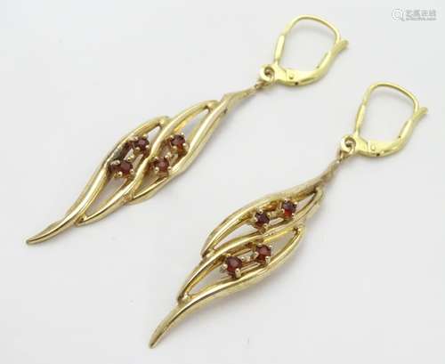 A pair of 9ct gold drop earrings of leaf form, each set with four garnet coloured stones. Approx.