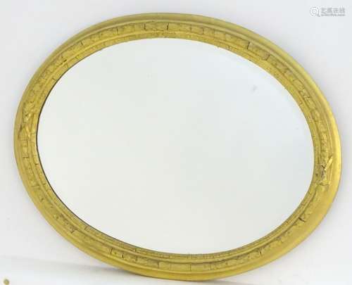 An early 20thC oval gilt mirror with a bevelled edge. 28 1/2