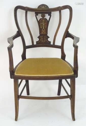 An Edwardian marquetry inlaid chair, with a shaped backrest, swept arms and standing on tapering