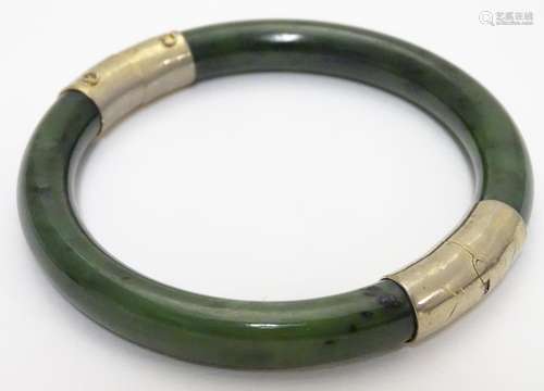 A bracelet of bangle form wit jade coloured hardstone set with gilt metal mounts. Please Note - we