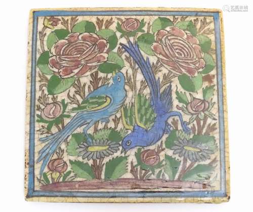 A Persian tile of square form decorated with stylised birds, flowers and foliage within a blue