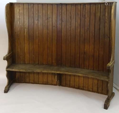 A 19thC tavern settle with an elm seat, planked bow back and shaped sides with scrolled armrests.