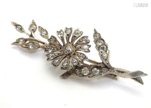 A brooch formed as a floral sprig set with white stones. 2 1/2