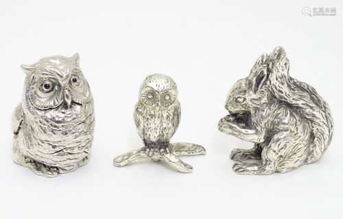 A silver model of an owl hallmarked London 1993 ( filled) together with a cast model of an owl on