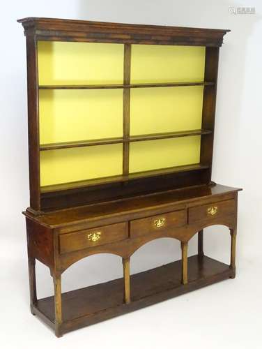 A mid 18thC walnut dresser with moulded cornice above an open three tier plate rack, the base having