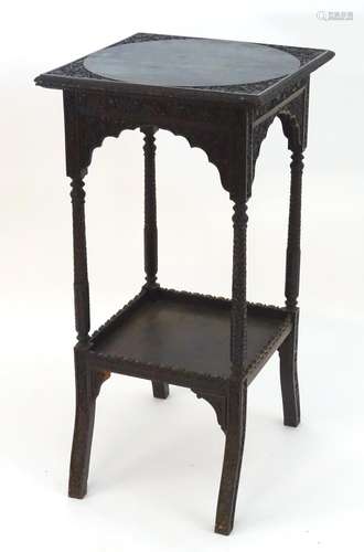 A late 19thC Chinese hardwood stand with two squared tiers, the top tier having carved decoration