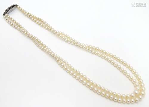 A double strand pearl necklace / choker of graduated pearls with silver and marcasite clasp.