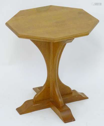 An early / mid 20thC oak Cotswold school table with an octagonal top above a chamfered frame and