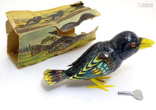 Toys: A 20thC West Germany Kohler tin plate clockwork / wind up starling / bird, with original