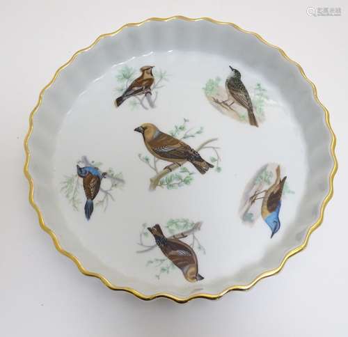 A French L Lourioux Le Faune pie dish with fluted sides and gilt rim, decorated with six birds to