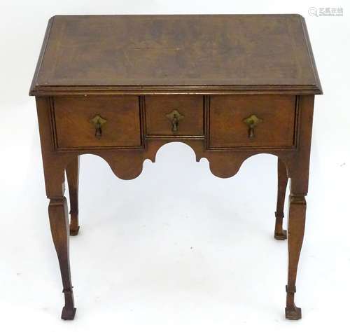 A George I style walnut lowboy with a rectangular feather banded top above three short drawers