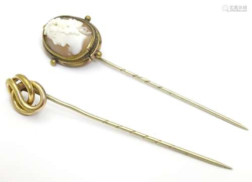 A gilt metal stick pin surmounted by a cameo together with a gilt metal stick pin with knot