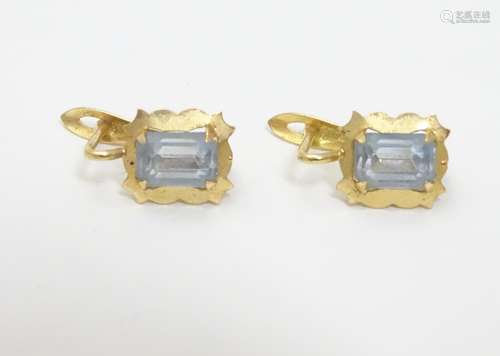 A pair of gold earrings set with pale blue paste stones. Approx 1/