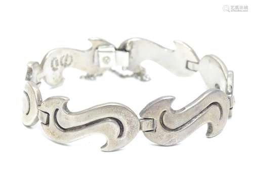 A Mexican sterling silver bracelet consisting of six conjoined elongated S shaped sections; fitted