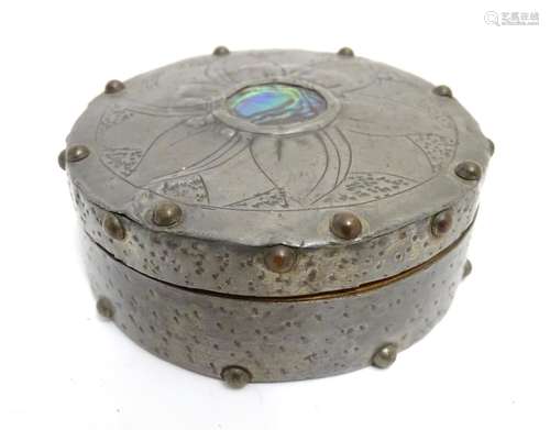 An Arts and Crafts turned wooden lidded pot of circular form with pewter covering and stud detail,