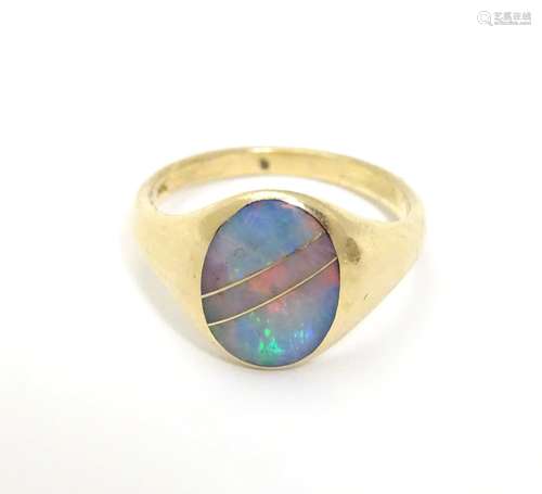 A 14ct gold ring set with opal in an Art Deco setting with gold line detail. Ring size approx L