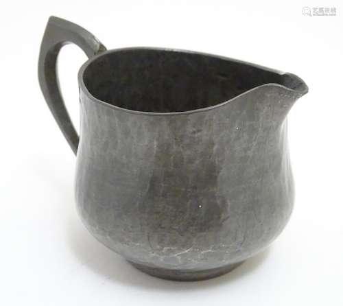 A Hugh Wallis Arts and Crafts hammered pewter cream jug. Stamped with maker's mark under. Approx.