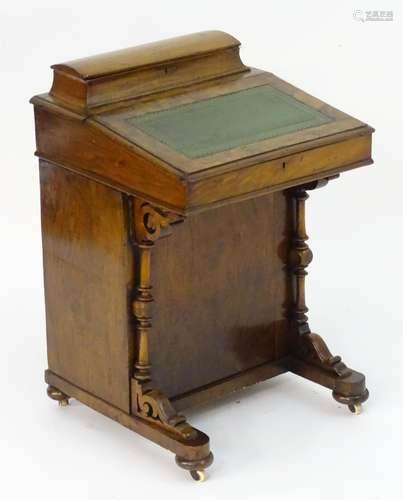 A mid 19thC walnut Davenport with a gold tool leather top and a lidded compartment containing fitted