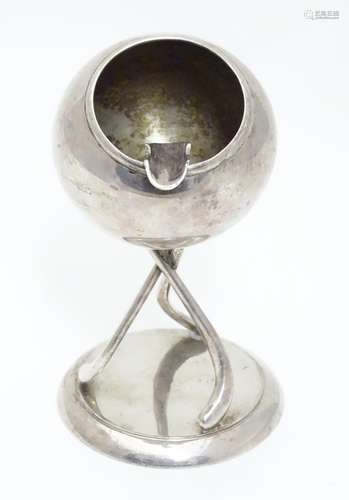 A novelty silver plate ashtray formed as a hockey ball supported on a base formed as three hockey