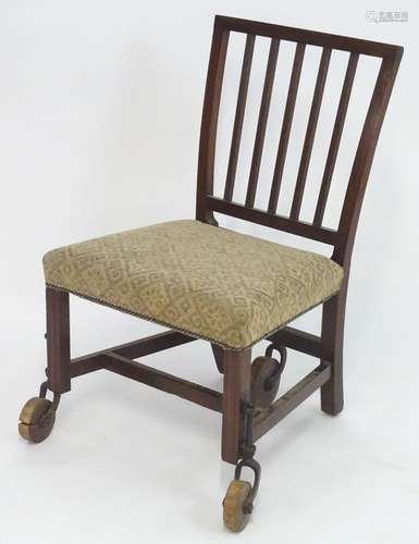 A Georgian mahogany chair raised on large wooden castors with a mechanical action, having a