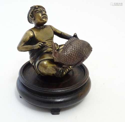 A Japanese bronze modelled as a seated fishmerman with a large fish, with an associated wooden base.