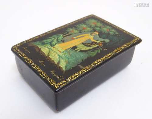 A 20thC Russian papier mache lacquered box with a hinged lid depicting a winter forest scene with